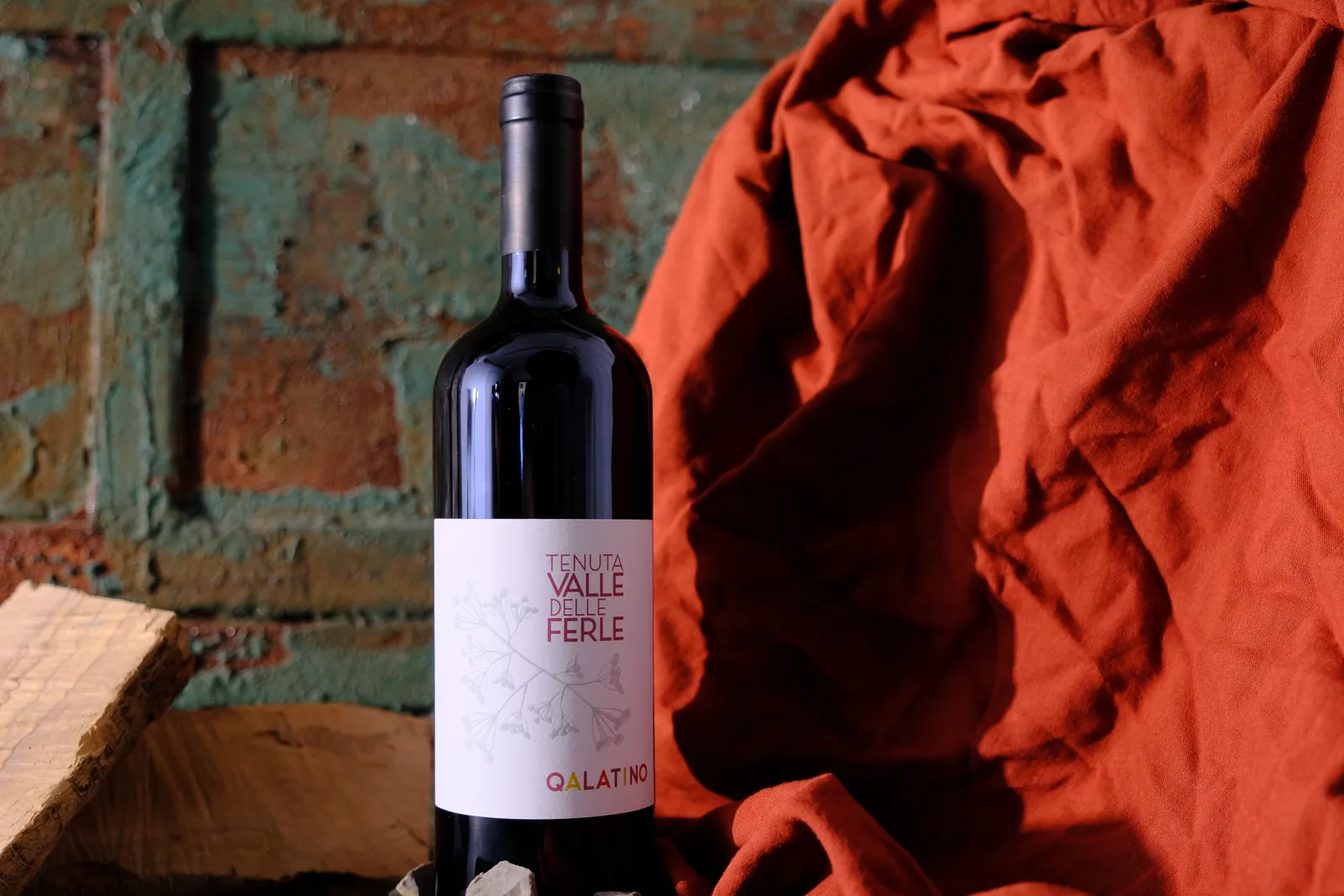 Still life — bottiglia di vino con drappo arancione